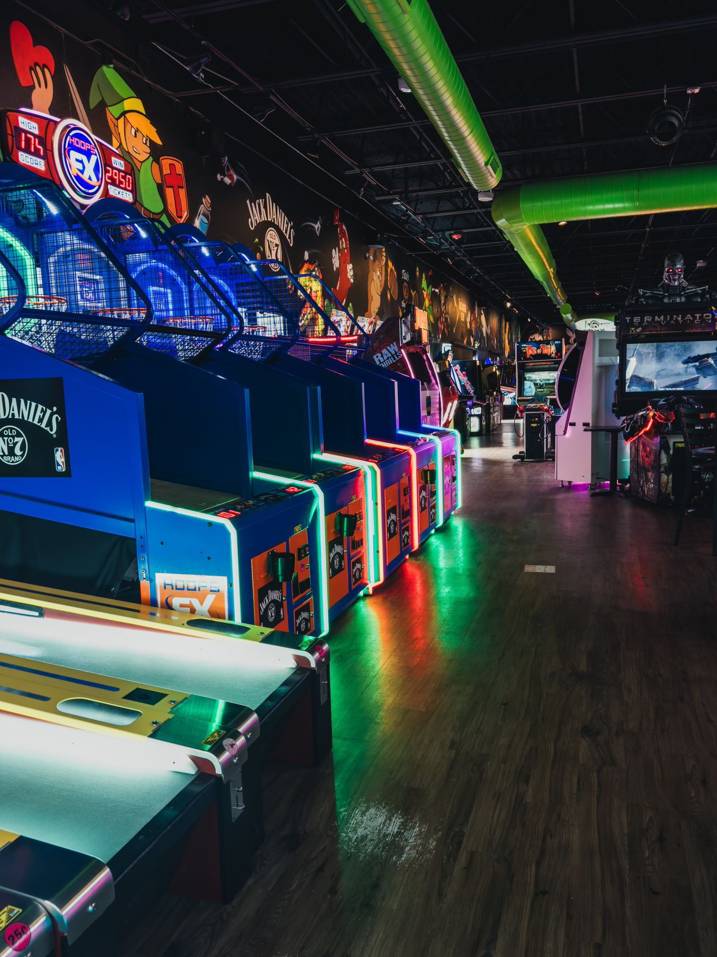 Neon-lit arcade with rows of game machines